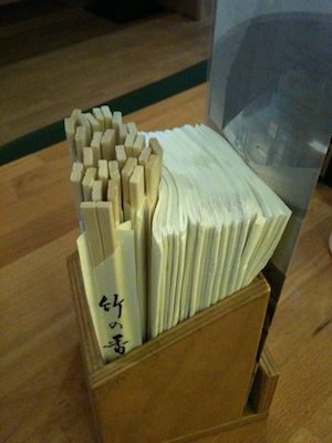 Napkins and paper-wrapped packs of chopsticks, crammed together into a wooden box.