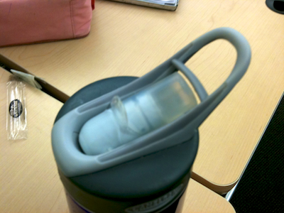 Design for a water bottle spout that features a thin plastic barrier between finger loop and spout