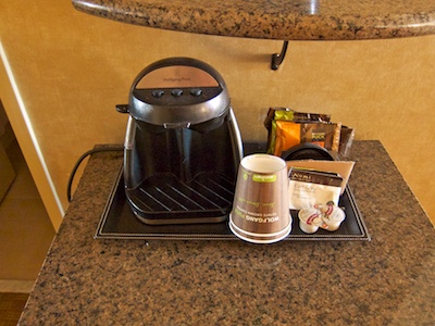 Small, two-cop coffee maker plus paper cups, coffee pouches, and condiments