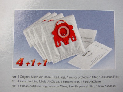 A photo and the line '4 + 1 + 1' show that this box bundles dust bags with motor and exhaust filters.