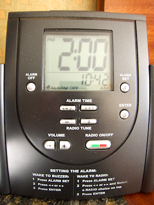 The front panel of the clock with display, control buttons, and printed-on instructions