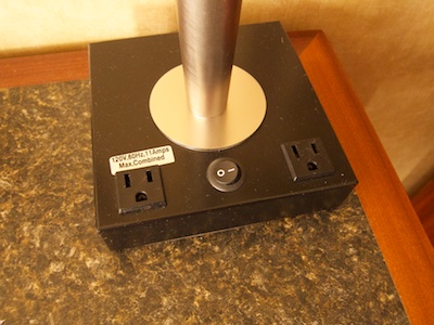 Base of the desk lamp with the lamp's power switch and two 110V power sockets