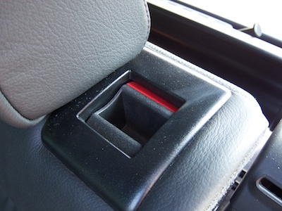 Handle integrated into the rear seat back in the unlocked position, revealing a red area on the handle.