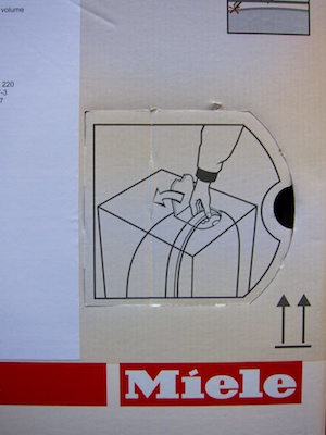 The lid on the side of the box is pre-cut on three of its four sides and bears a graphic that illustrates how to open it, and what to grab on the inside.