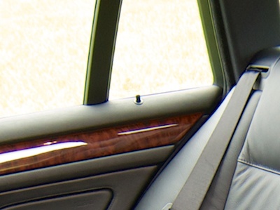Inside view of a car's rear door with lock pin sticking out from the top of the inside door cover.